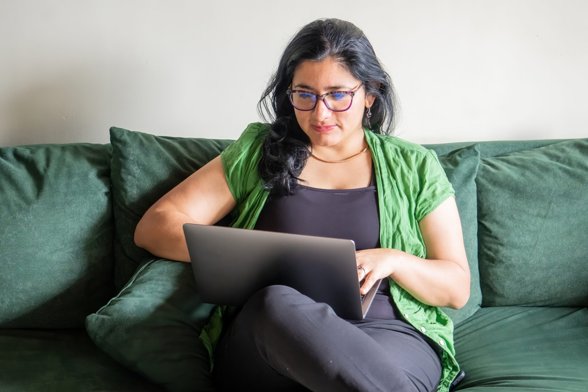A woman is sitting on a couch and using a laptop How It Works in Naperville, IL